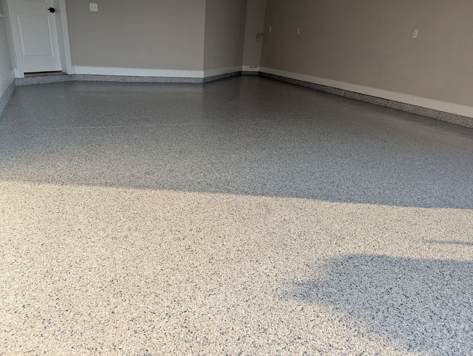 Wide finished grey-and-cream flake epoxy garage floor